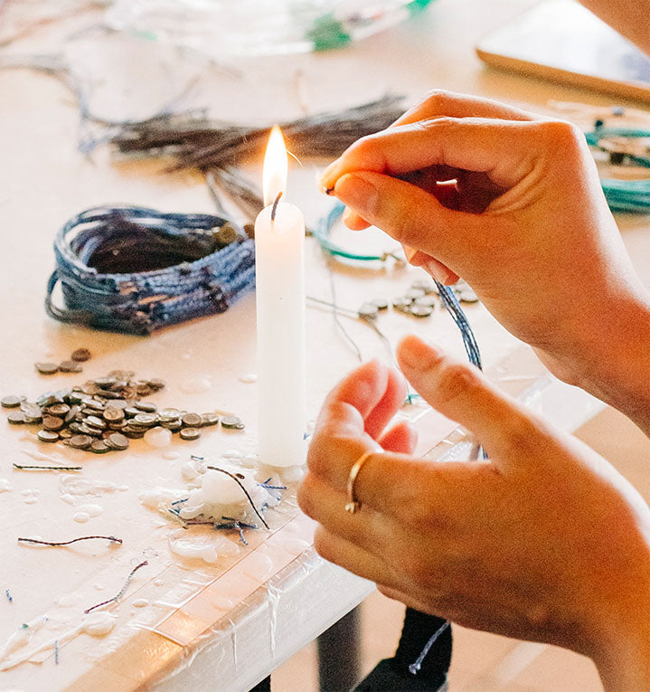 hands melting the bracelet wax with a candle