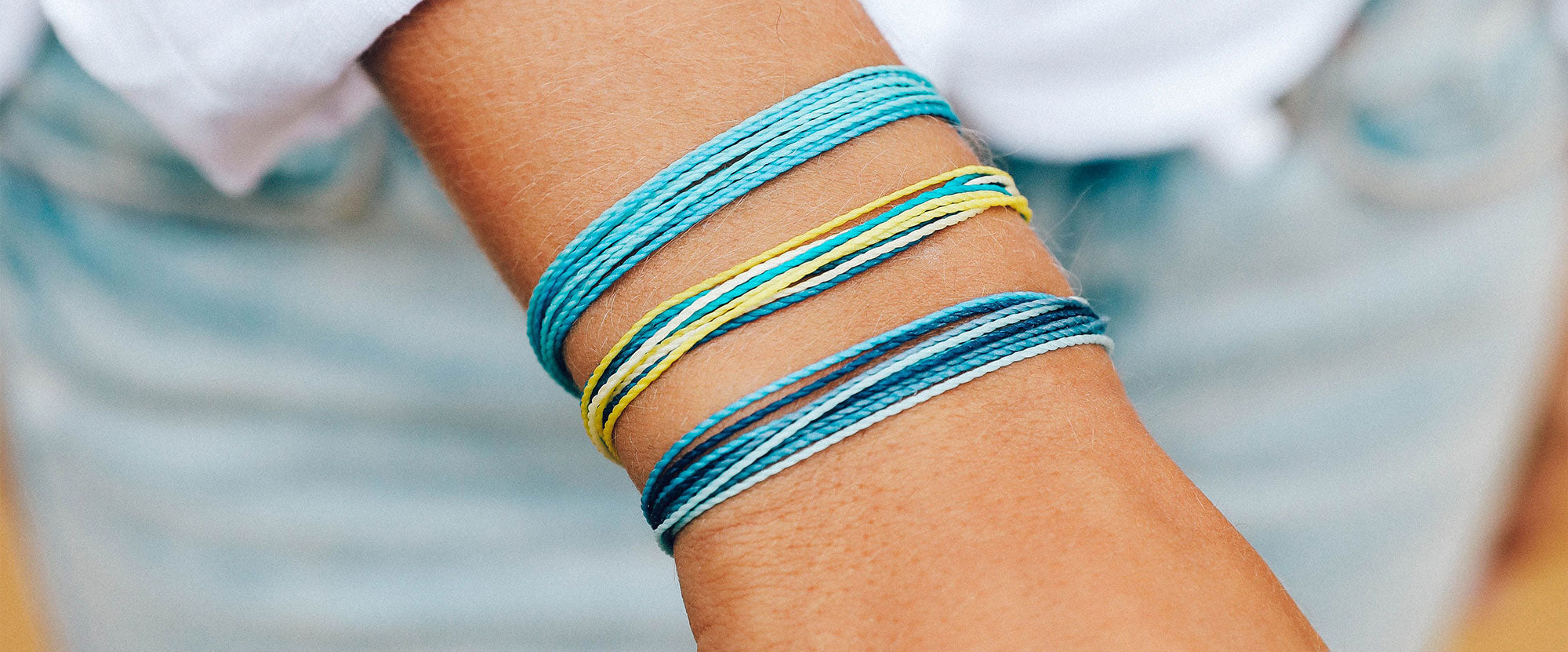 hand wearing pura vida braclets